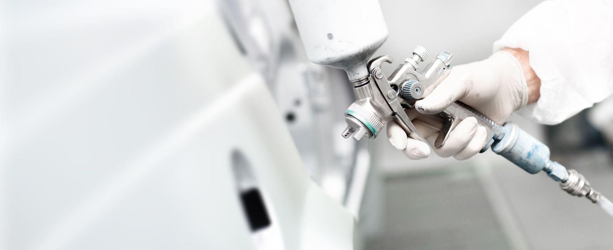 Lackierer lackiert ein Auto weiß